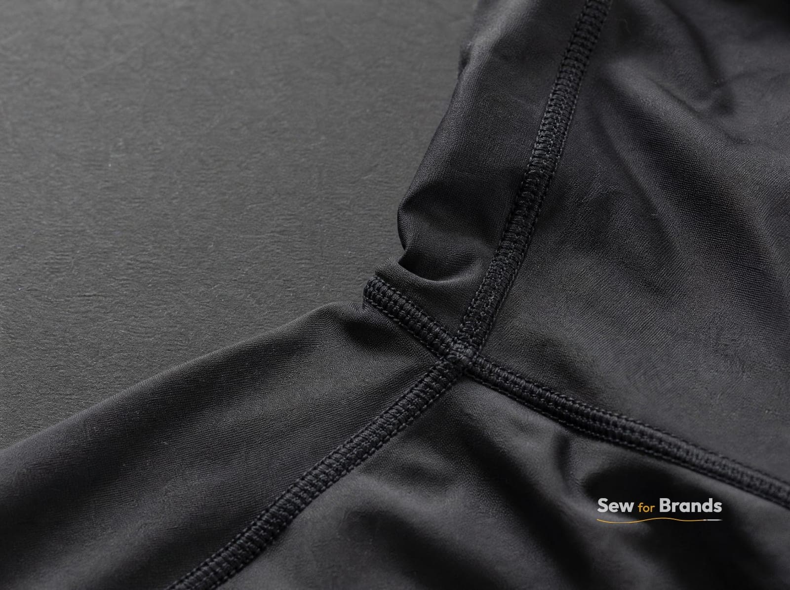 Flatlock stitched seam on a black rash guard, close-up