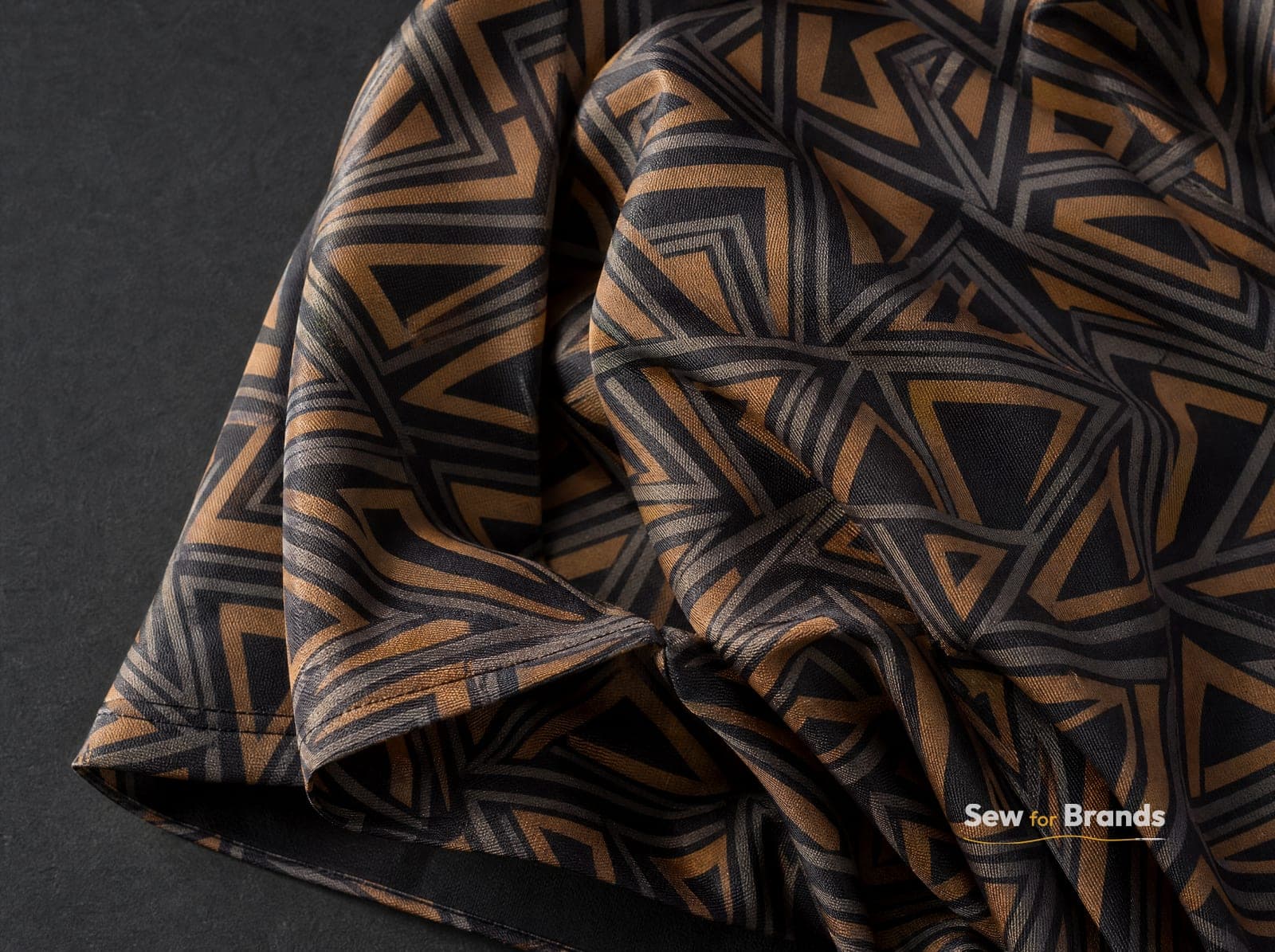Close-up of sublimated geometric pattern fabric in graphite and amber tones