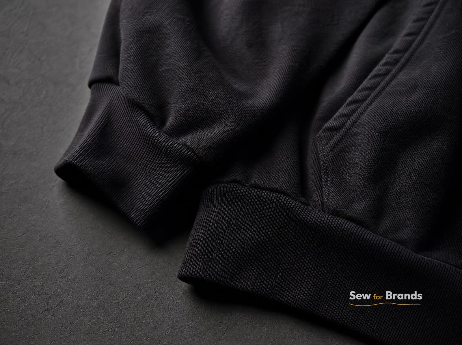 Close-up of ribbed cuff and hem on a black fleece hoodie