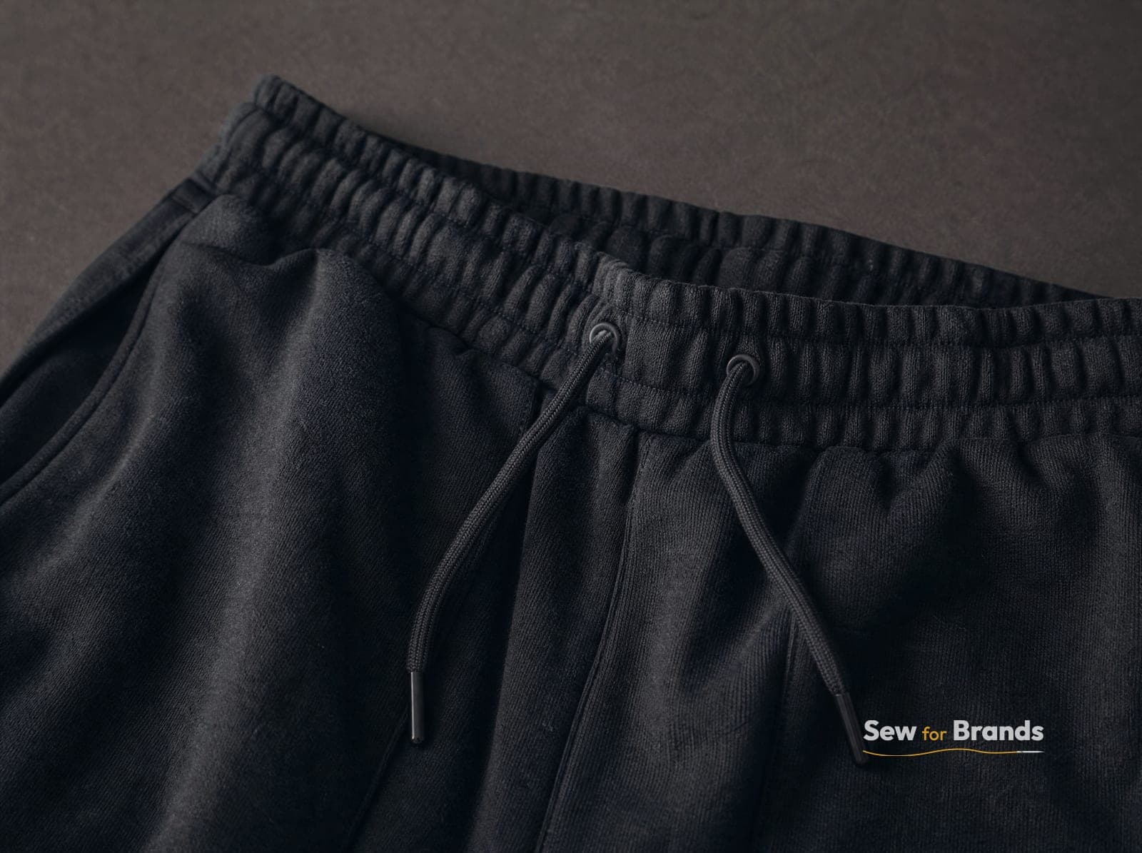 Drawcord waistband of black joggers, close-up