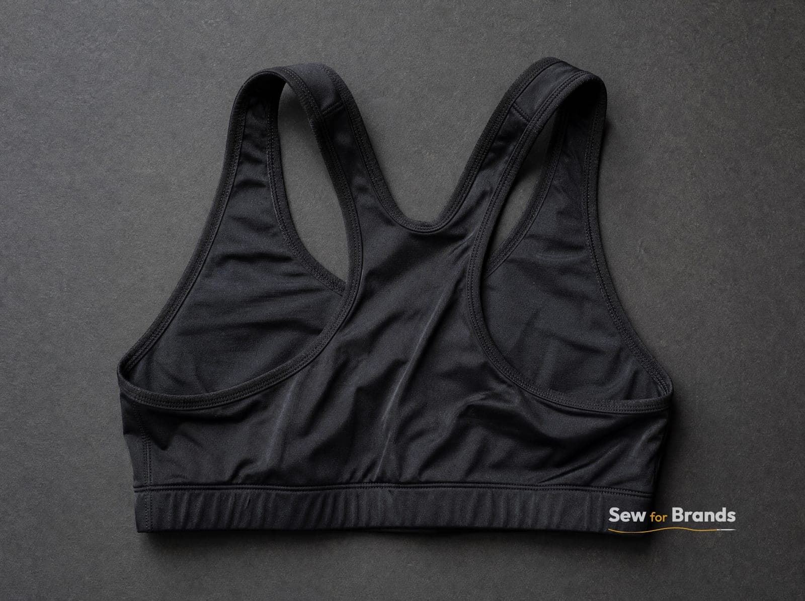 Back of a black racerback sports bra showing straps