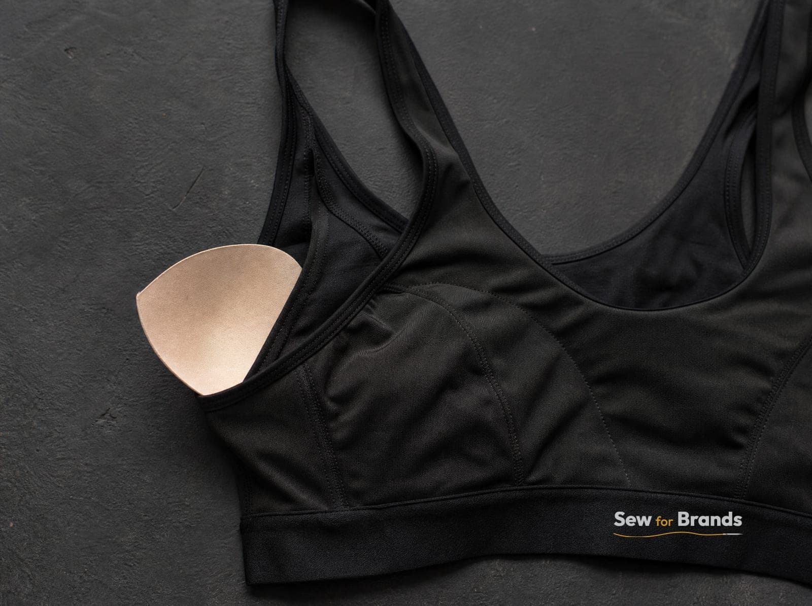 Removable bra pad half pulled out of a black sports bra