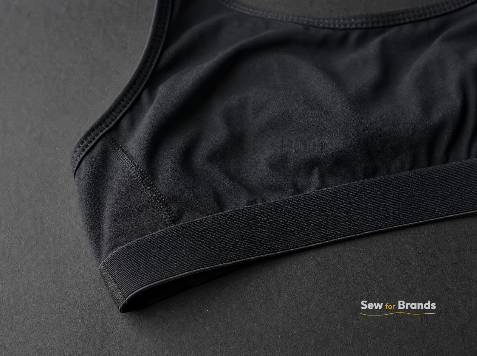 Macro of the bonded underband edge of a black sports bra