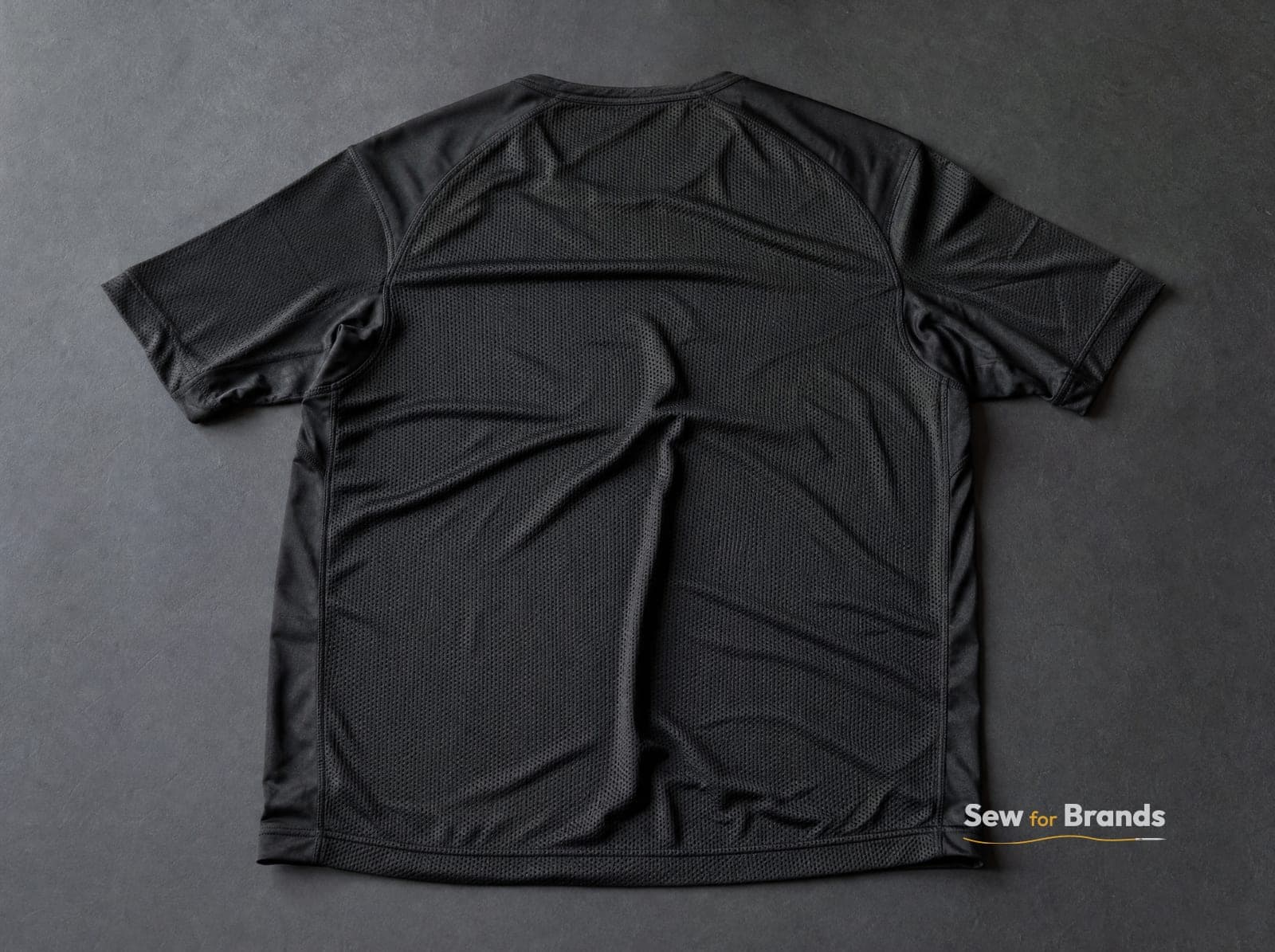 Mesh back panel of a black performance tee